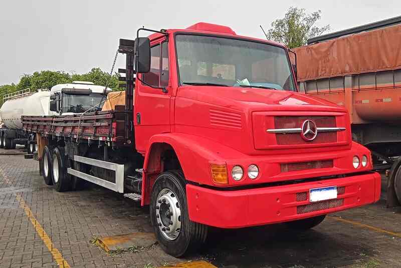 Caminhão Mercedes vermelho estacionado, analisado durante perícia técnica para identificação de defeitos e avaliações judiciais.