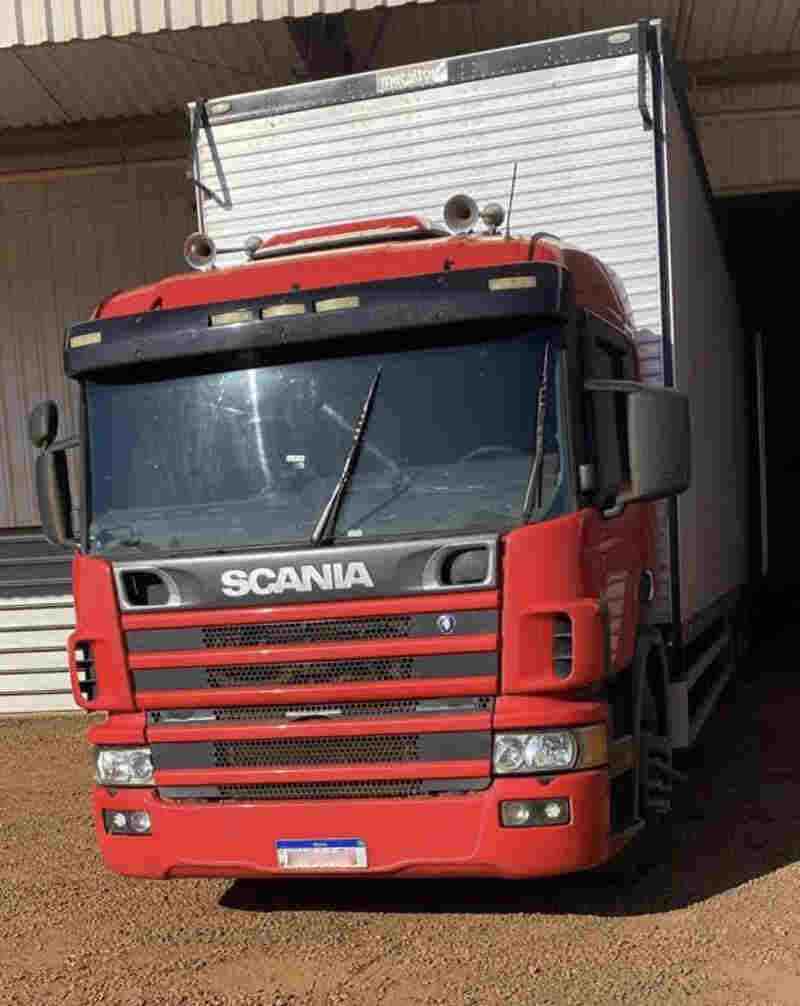 Caminhão Scania vermelho em análise técnica de motor e diagnóstico de falhas mecânicas para processos judiciais.