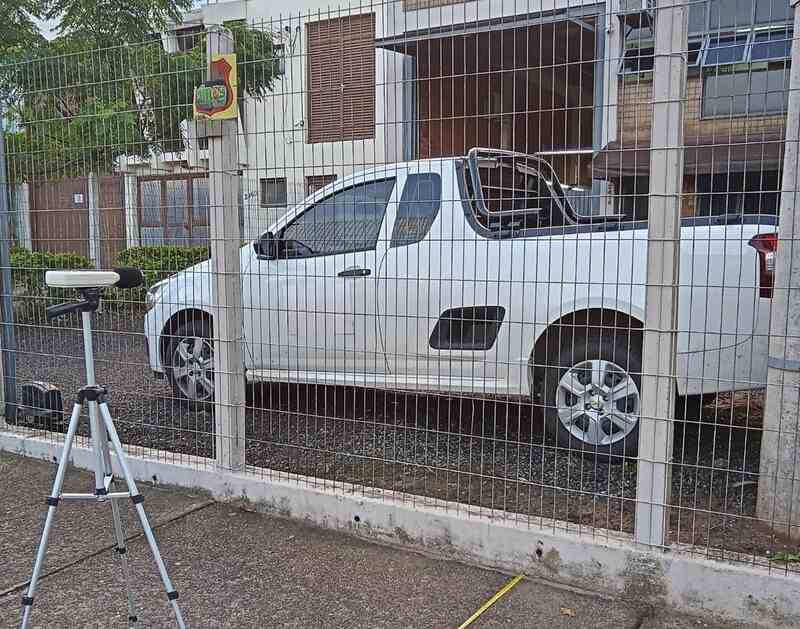 Equipamento de medição de ruído ambiental montado em tripé próximo a uma área industrial, representando serviços de laudo de ruído urbano para estudos de impacto de vizinhança.