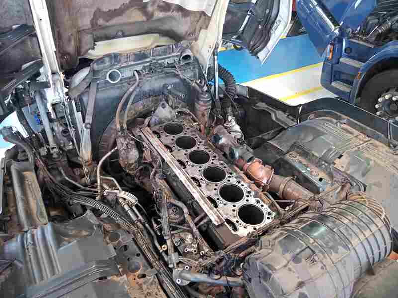 Motor de caminhão desmontado em análise técnica para avaliação de falhas em bloco e resolução de disputas de garantia.