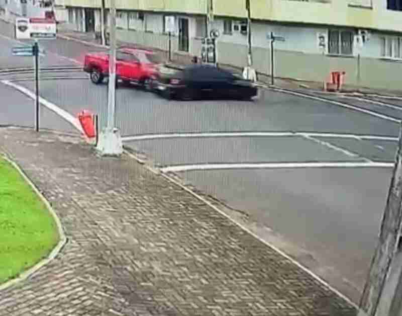 Imagem de acidente de trânsito envolvendo uma caminhonete vermelha e um sedã preto em cruzamento, representando serviços de perícia técnica para análise detalhada de colisões e responsabilidades.