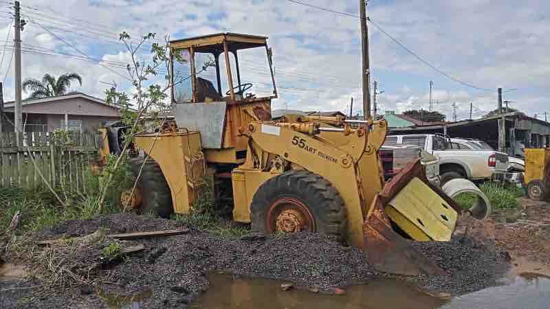 Retroescavadeira amarela em análise pericial técnica para avaliar condições de segurança e desgaste em ambiente agrícola.